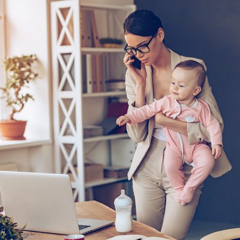 Mother holding child while working