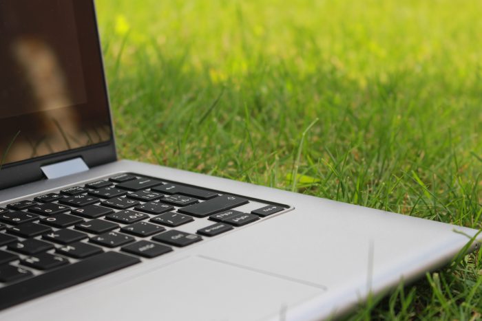 Open laptop on a grassy field