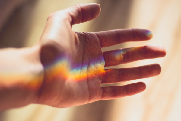 hand with refracted rainbow light
