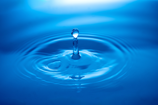 closeup of water drop in blue water ripple