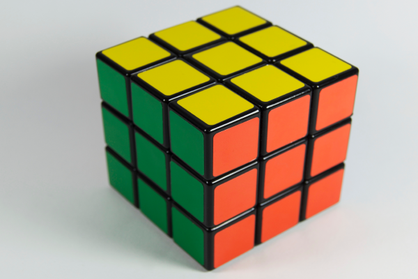 a rubik's cube displaying yellow green and orange sides solved