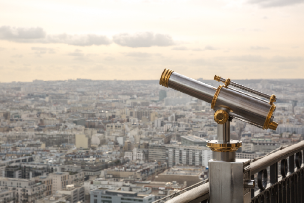 a telescope on a balcony looking over a city