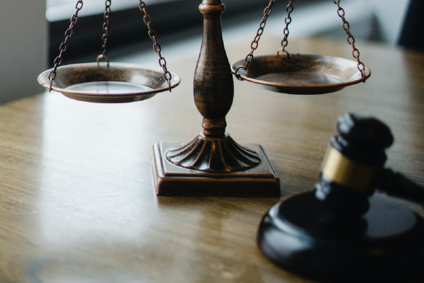 image of scales of justice and a gavel on a desk