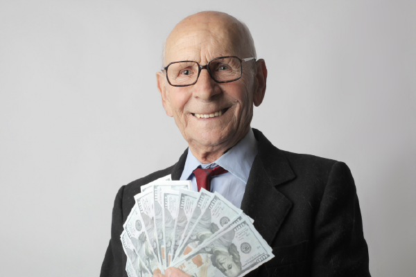 an older person holding fanned out money
