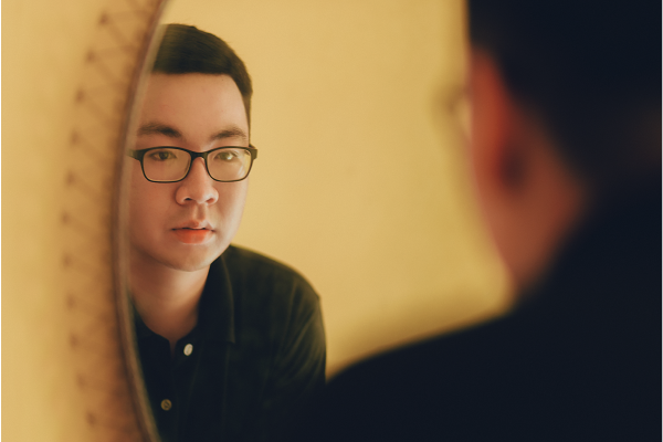 an image of a person looking at their reflection in a mirror with a focused gaze