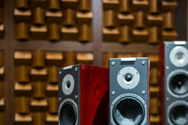 an image of three large speakers with a sound absorbing wall in the background