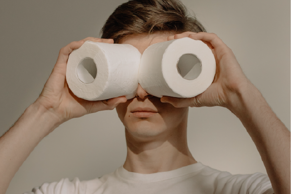 an image of a person holding up toilet paper rolls to their eyes like binoculars